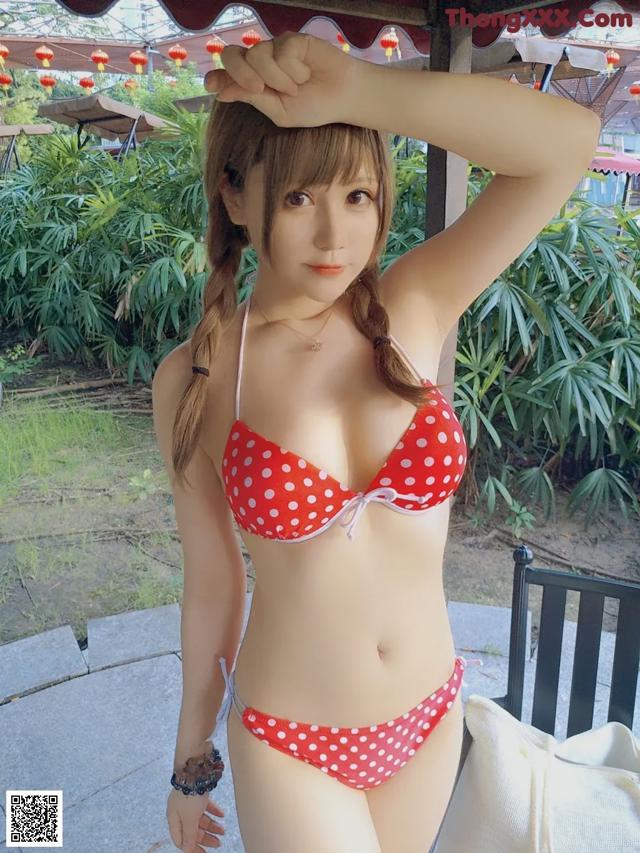 A woman in a red and white polka dot bikini posing for a picture.