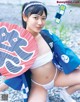 A woman in a white bikini holding a red and blue umbrella.