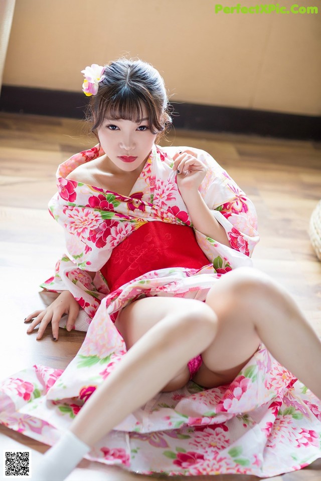 A woman in a kimono sitting on the floor.