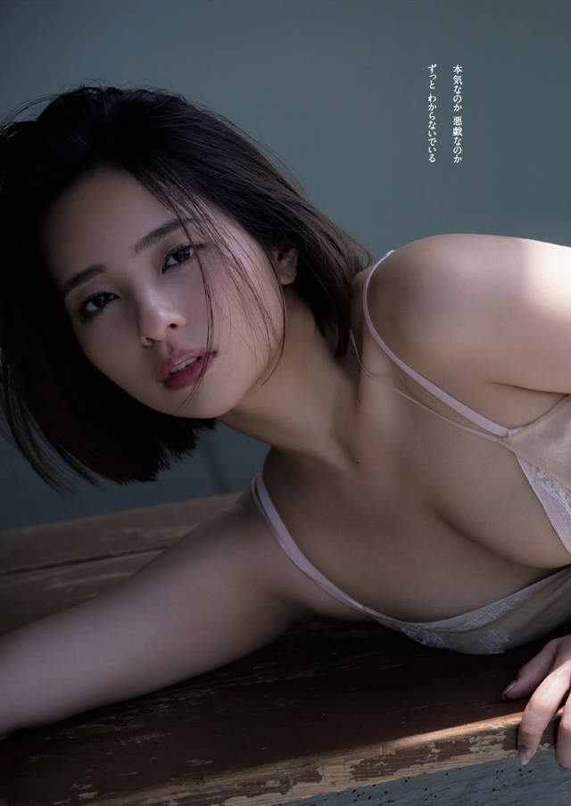 A woman in lingerie laying on a wooden table.